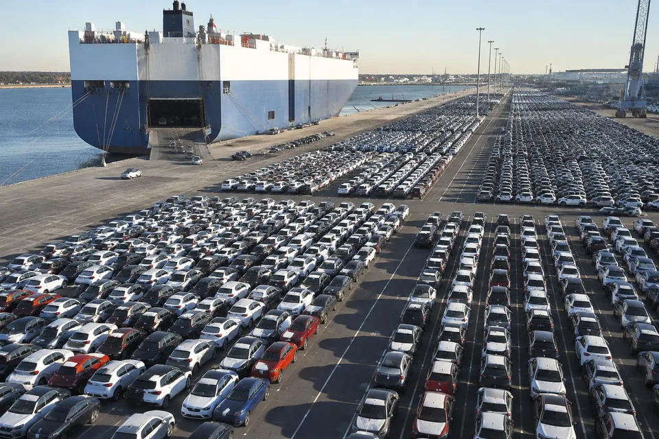 Imagine generată de AI: Luftaufnahme eines Hafenterminals mit Reihen von Neuwagen und einem Autotransportschiff, KI-Bild